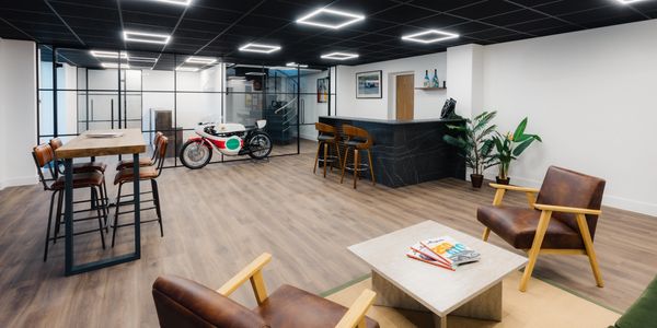 Inside The Pavilion at BarnTech with bar seating, lounge chairs and a classic race motorcycle on display
